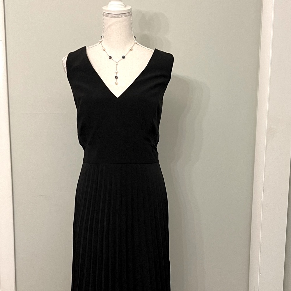 Gorgeous black polyester and spandex lined v-neck gown with pleated skirt.